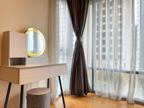 Una habitación moderna con un escritorio de madera, un espejo redondo y un taburete pequeño.