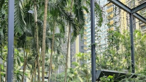 A view of a lush indoor garden with a pool, surrounded by tall palm trees and dense foliage. - St Mary Residences Luxury Apartments (Kuala Lumpur)