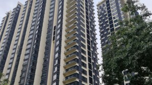A high-rise residential building with multiple balconies, surrounded by greenery and other buildings. - St Mary Residences Luxury Apartments (Kuala Lumpur)
