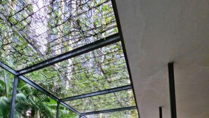 A modern atrium with glass walls, a central staircase, and lush greenery. - St Mary Residences Luxury Apartments (Kuala Lumpur)