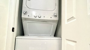 Una lavadora y secadora compactas en un lavadero pequeño.