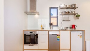 A compact kitchen with a built-in oven, dishwasher, and refrigerator.