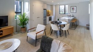 A modern apartment with a living room, dining area, kitchen, and a TV. - Luxe Central City 2 bedrooms with Carpark (Christchurch)