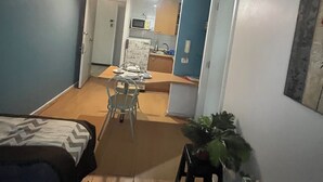 Un espacio habitable compacto con kitchenette, comedor y dormitorio.