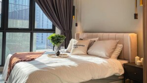 Un dormitorio moderno con una cama grande, una mesita de noche, un ventilador de techo y una ventana con cortinas.