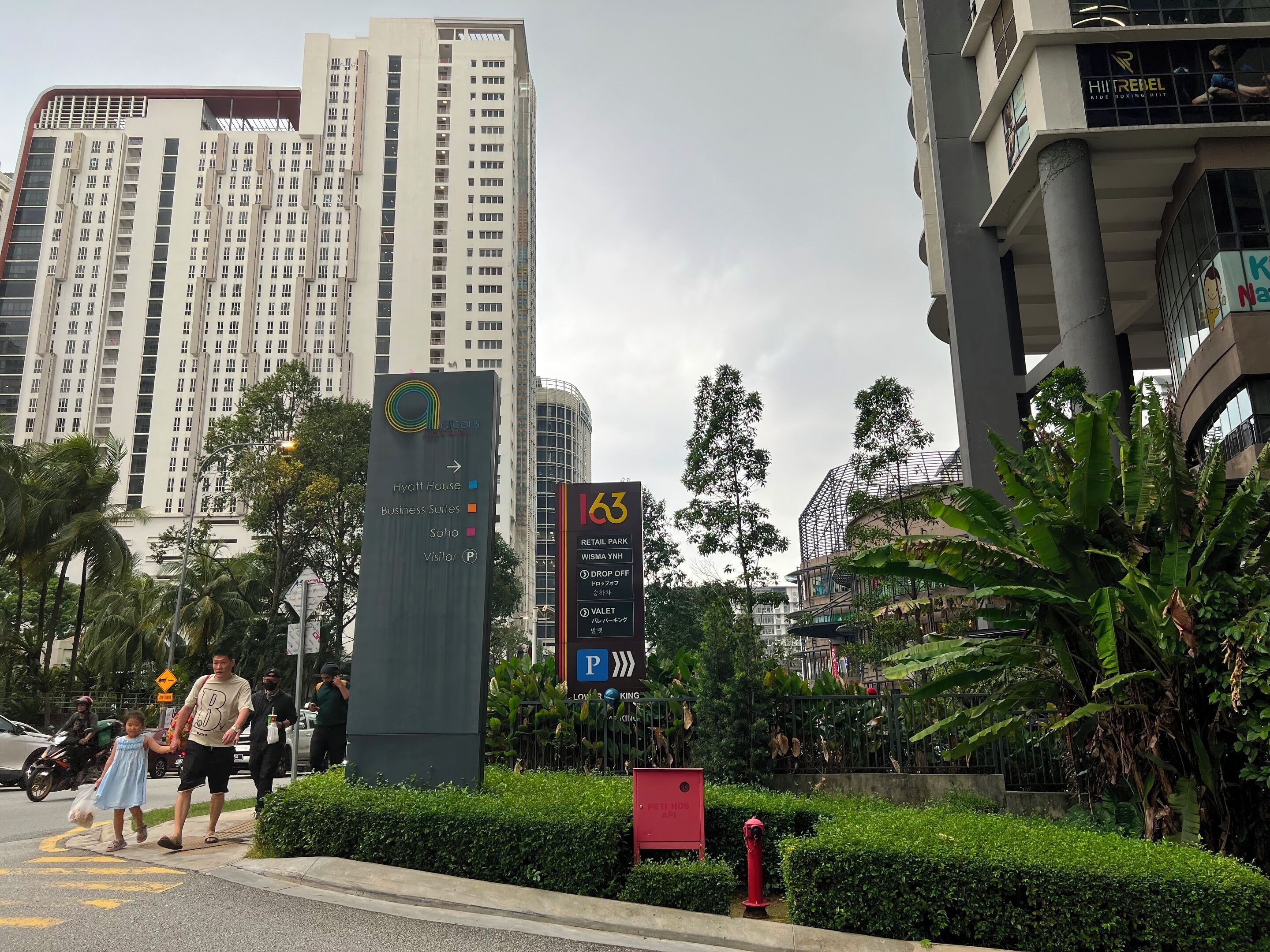 Ein hohes Gebäude mit einem Schild, das anzeigt, dass es ein Hotel, Bürosuiten und einen Besucherparkplatz beherbergt.