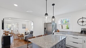 A modern kitchen with granite countertops, stainless steel appliances, and pendant lighting. - Greenville Bungalow Near Downtown + Swamp Rabbit (Greenville)