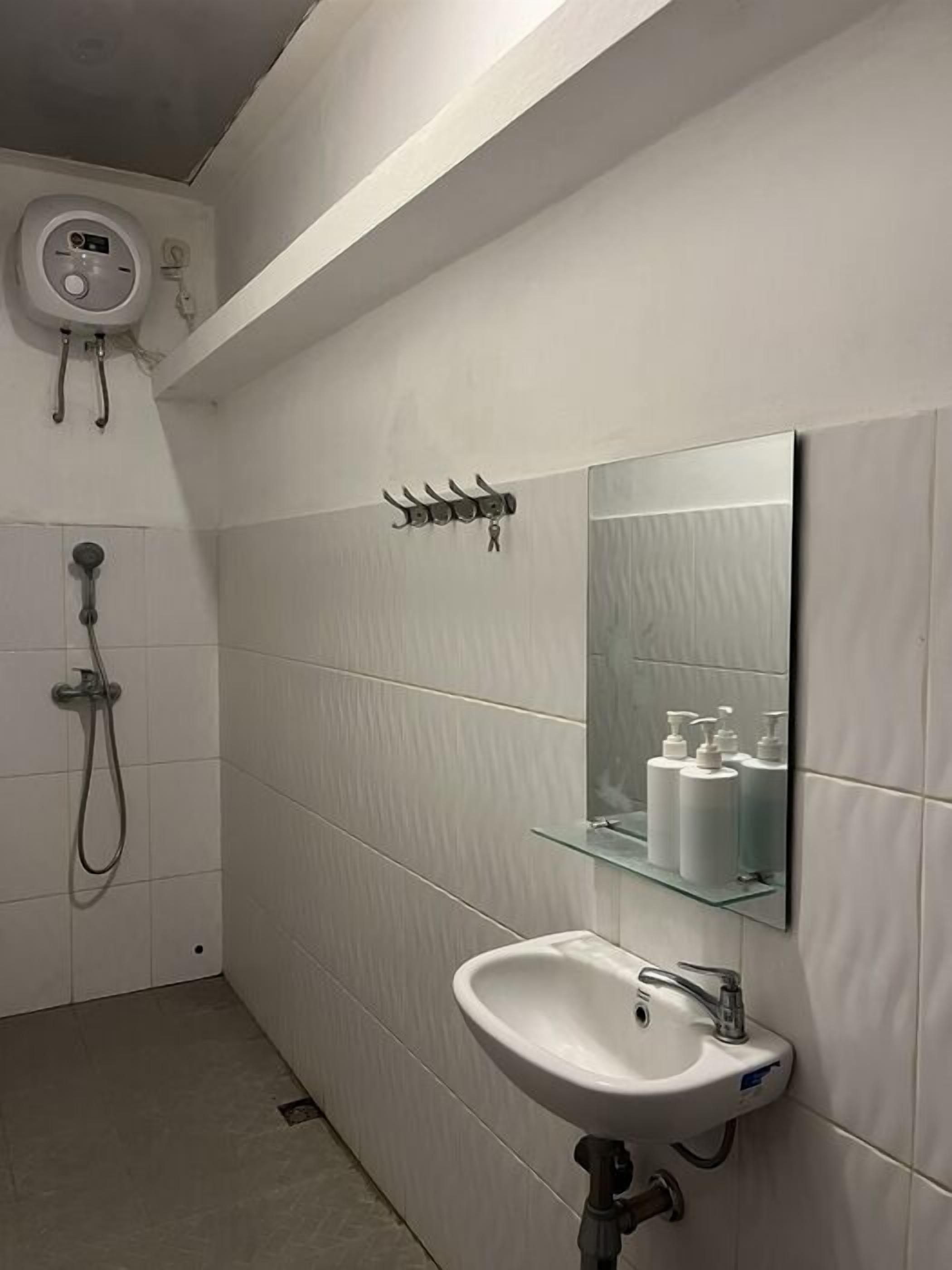 A bathroom with a white sink, a mirror, and a shower.