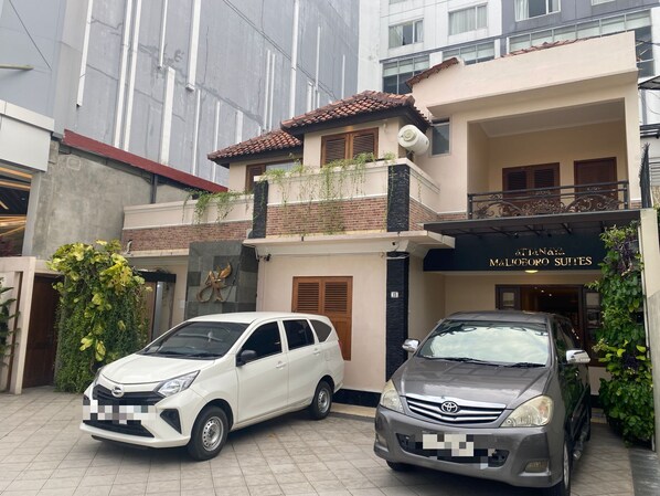 Un edificio de dos pisos con un letrero que dice 'Malioeoro Suites'.