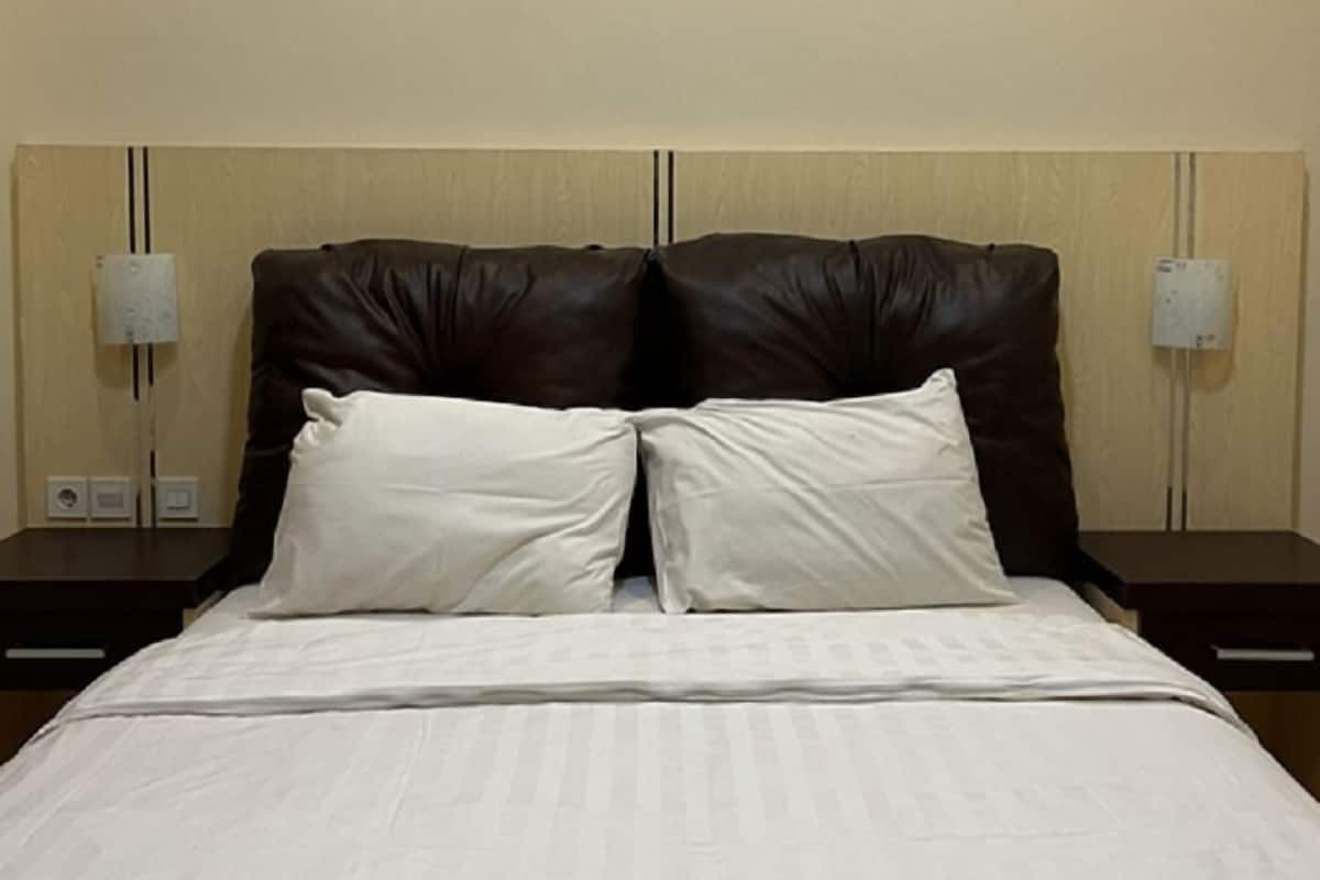 Ein Hotelzimmer mit einem großen Bett, zwei Nachttischen und einem Kopfteil mit Wandlampen.