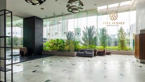 A modern lobby with a glass wall, a reception desk, and seating area.