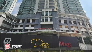 A high-rise building with multiple balconies and a sign for 'Dua Sentral'.