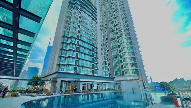 A high-rise building with a swimming pool and lounge area.