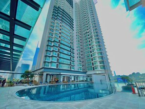 Un edificio de gran altura con piscina y zona de descanso.