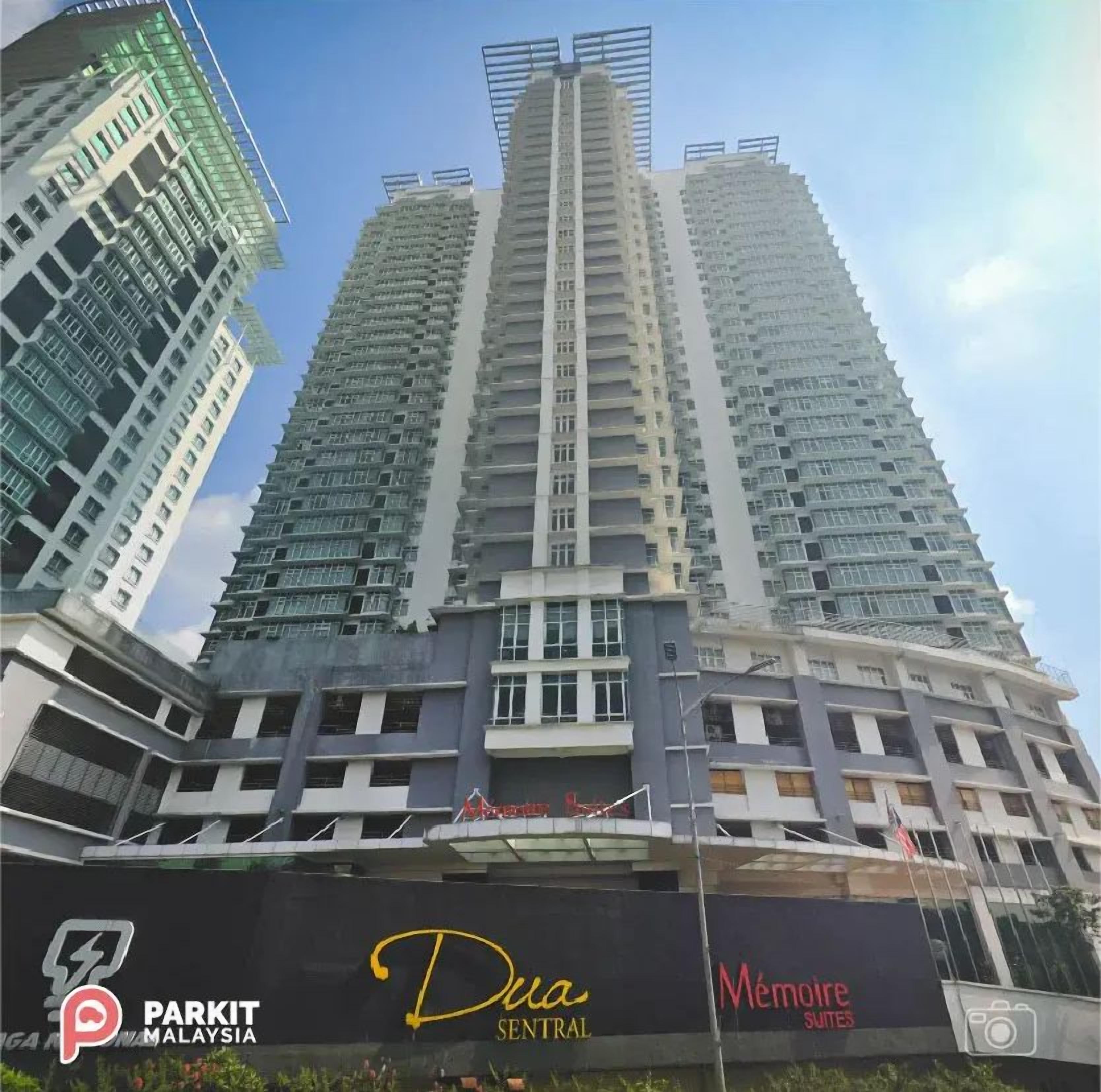A high-rise building with multiple balconies and a sign for 'Dua Sentral'.