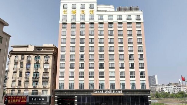 Korkea hotellirakennus, jossa on useita kerroksia, ja sen kyltissä lukee: ”Great Wall Hotel”.