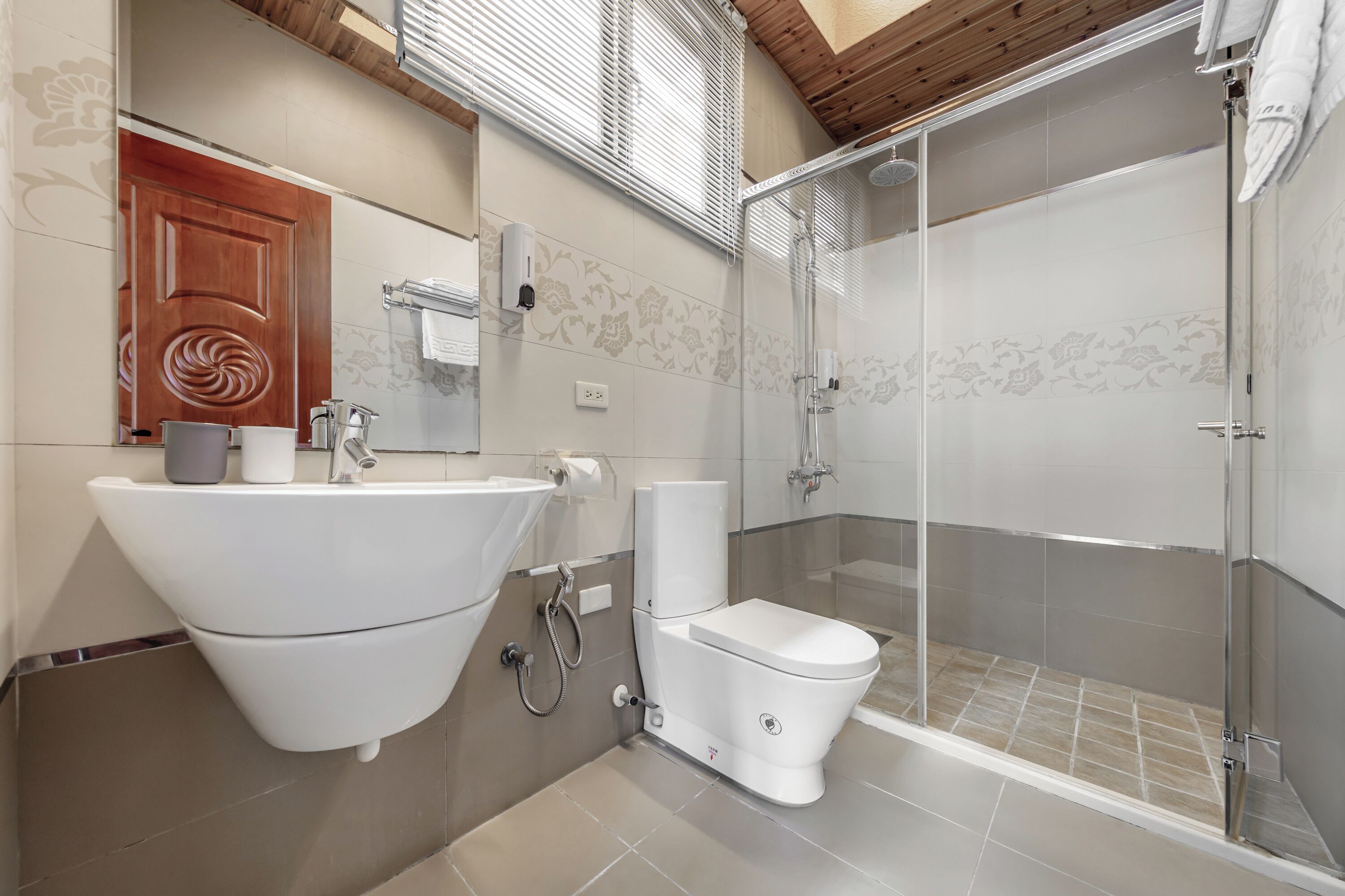 A modern bathroom with a freestanding sink, toilet, and glass-enclosed shower.