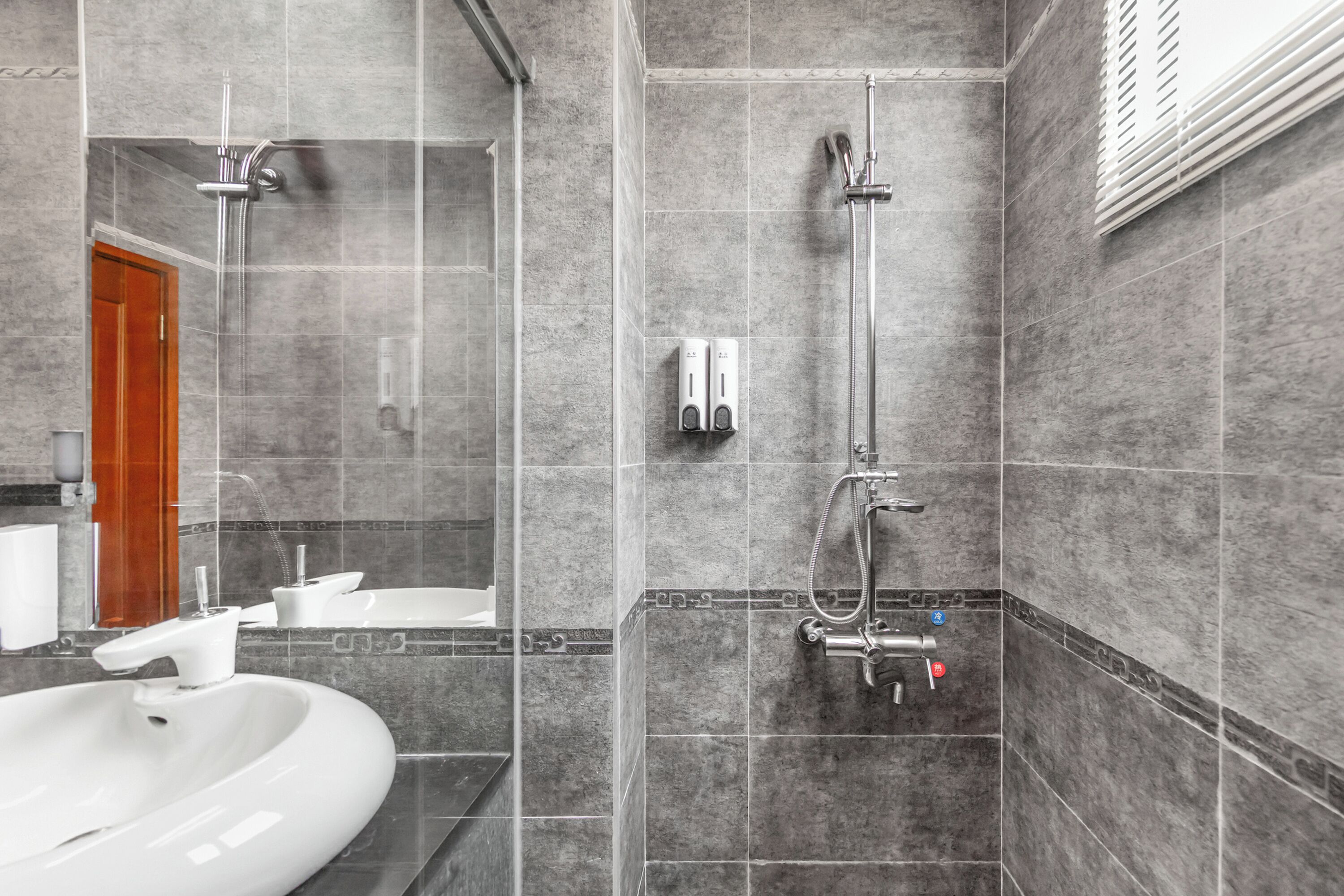 Ein modernes Badezimmer mit einem großen Waschbecken, einer Dusche und einem Spiegel.