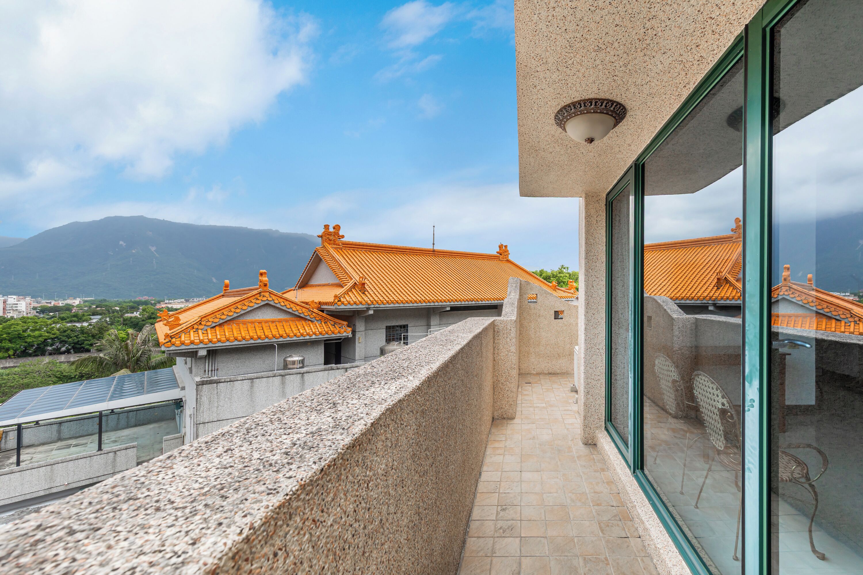 A balcony with a view of traditional buildings and a mountain.