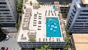 A rooftop pool with multiple sun loungers and a central flower-shaped water feature. - The Palms: Waikiki studio (Honolulu)