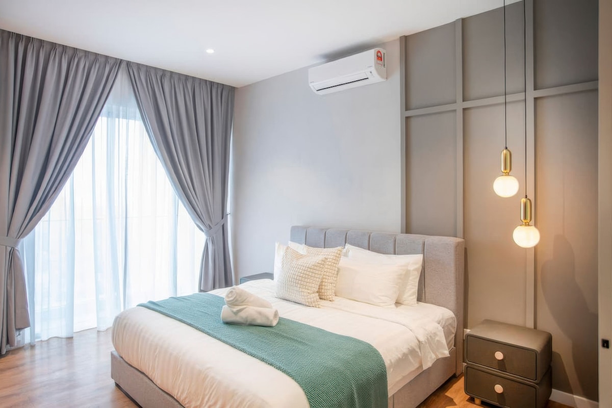 A modern bedroom with a large bed, grey curtains, an air conditioning unit, and a bedside table with drawers.