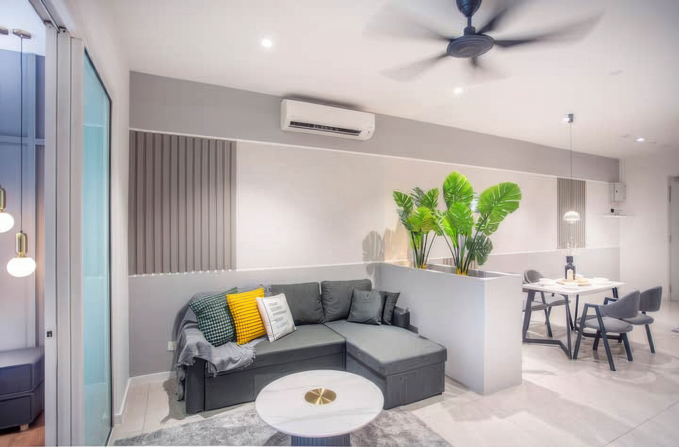 Una sala de estar moderna con un sofá seccional, una mesa de comedor con sillas, un ventilador de techo y una planta en maceta.