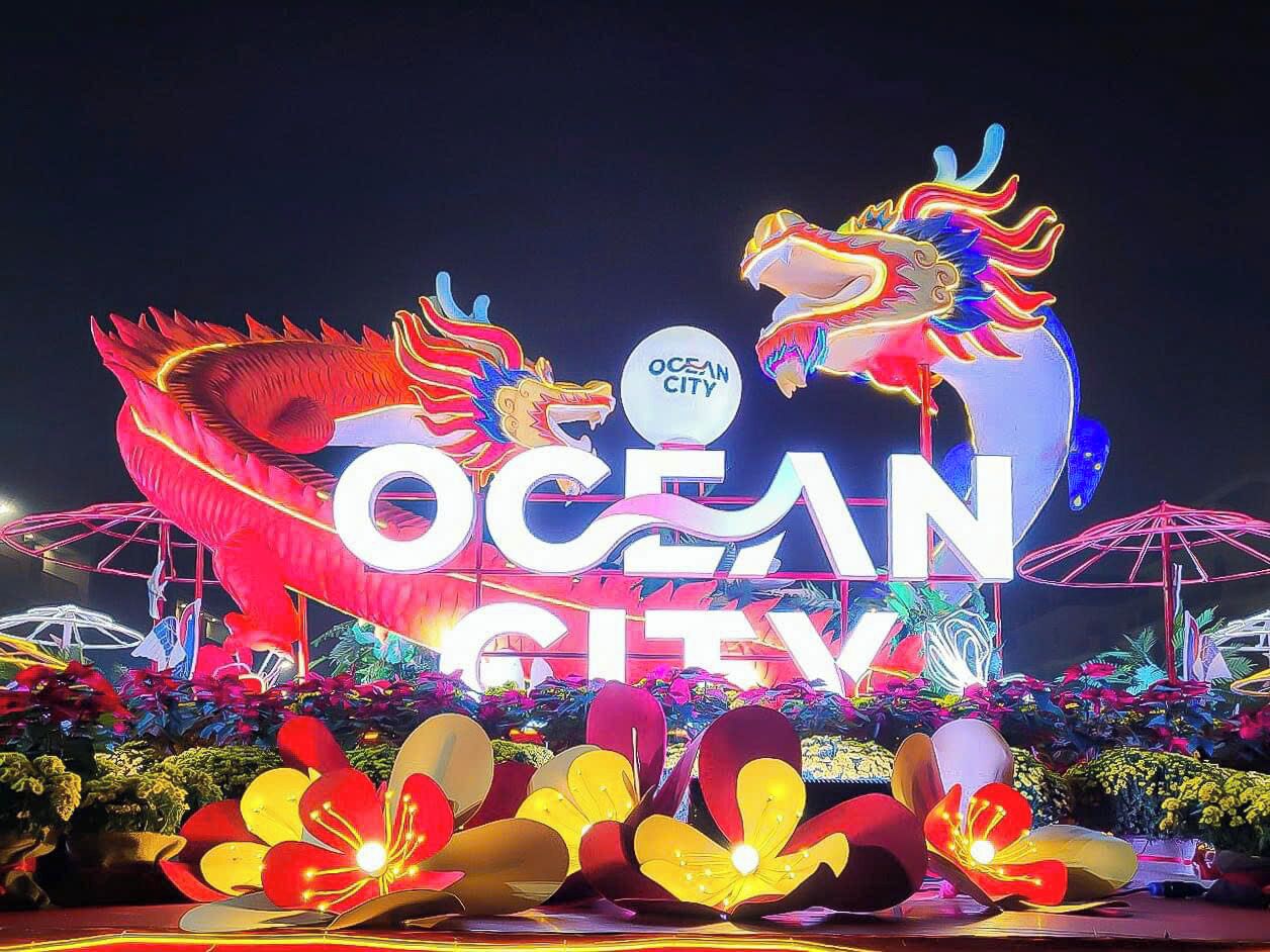 A brightly lit sign with "OCEAN CITY" and a dragon design, surrounded by colorful lights and floral decorations.