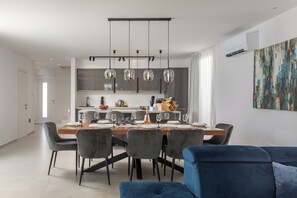 A modern dining area with a wooden table set for six, surrounded by grey upholstered chairs. - Villa Ivona di San Lorenzo Private Pool (Sveti Lovrec)