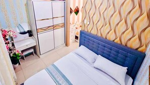 A bedroom with a bed, a dresser, a mirror, and a patterned wall.