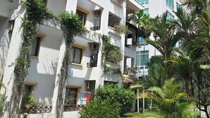 Un hôtel à plusieurs étages doté de balcons, dont certains sont ornés de plantes et de fleurs.