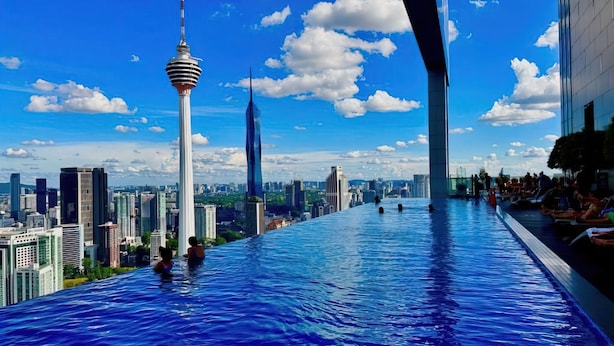 A rooftop infinity pool with a cityscape view, including a prominent tower and modern buildings. - The Platinum Suites by Emily in Town (Kuala Lumpur)