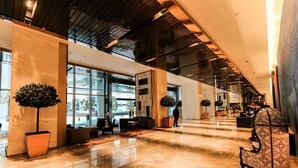 A spacious lobby with a high ceiling, large windows, and a polished marble floor. - The Platinum Suites by Emily in Town (Kuala Lumpur)