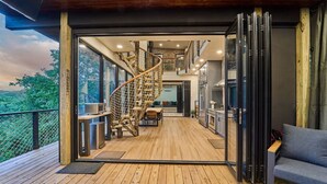 Ein modernes Interieur mit einer Wendeltreppe, einem Holzboden und Blick ins Freie.