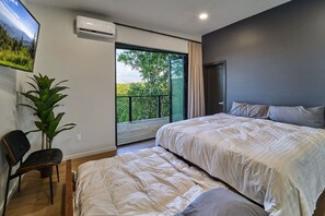 A bedroom with two beds, a chair, a potted plant, and a large window with a view of greenery. - Skyview Treehouse- luxury with breathtaking views (Sevierville)