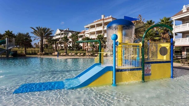 Una piscina con tobogán y puesto de socorristas.