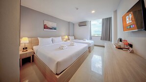 A hotel room with two beds, a flat-screen TV, a painting, and a view of the city. - B2 Sisaket Boutique & Budget Hotel (Sisaket)