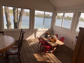 A covered deck with a table and chairs, overlooking a lake. - Game Room & Outdoor Fun - Gilead Lake Getaway! (Bronson)