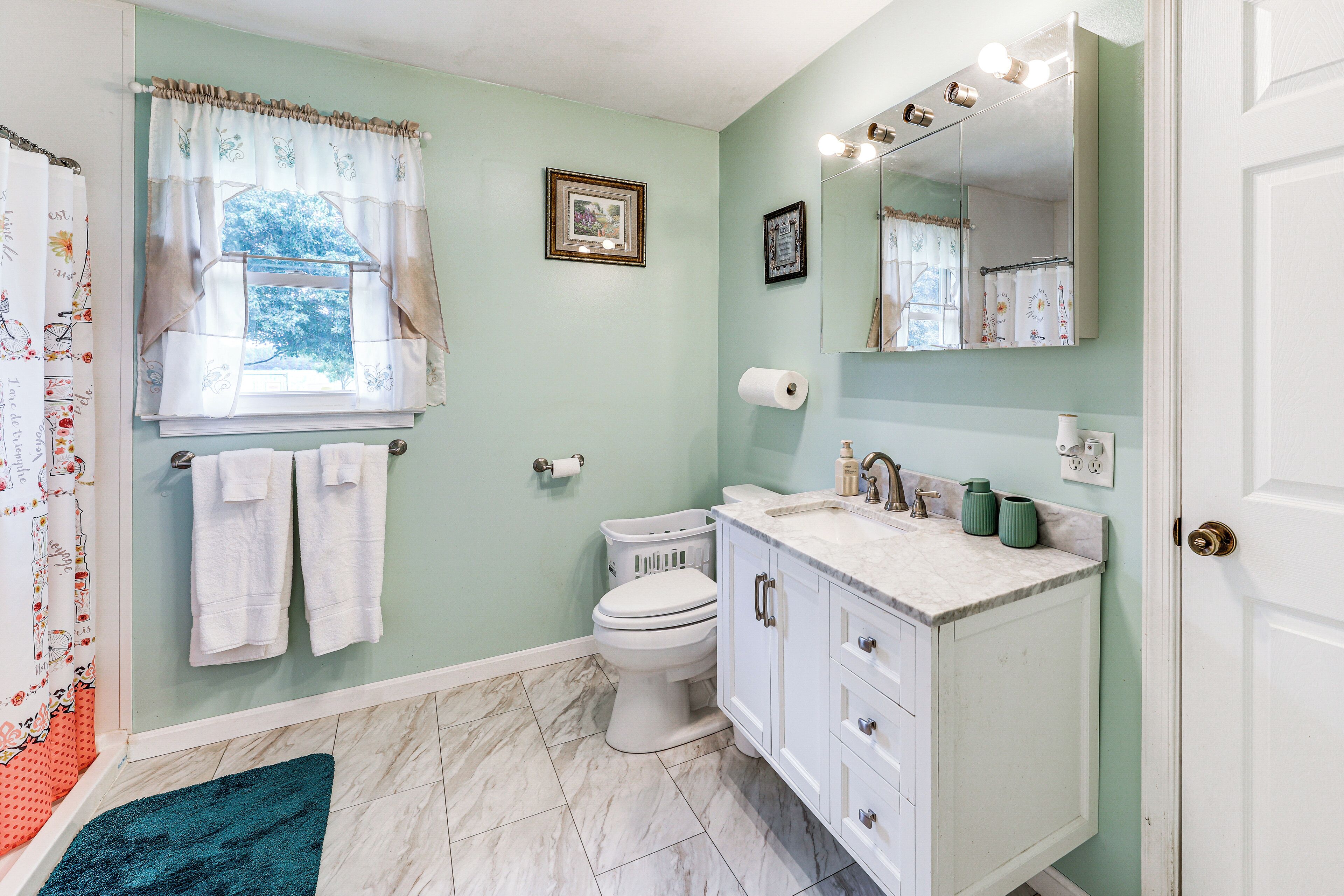 A bathroom with a toilet, sink, and shower curtain.