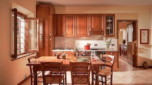 A kitchen with wooden cabinets, a dining table with chairs, and a window providing natural light.
