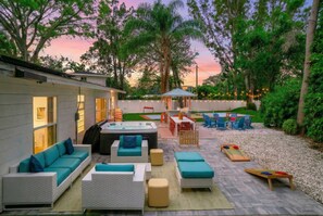Une terrasse avec mobilier d’extérieur, un jacuzzi et un espace salon abrité.