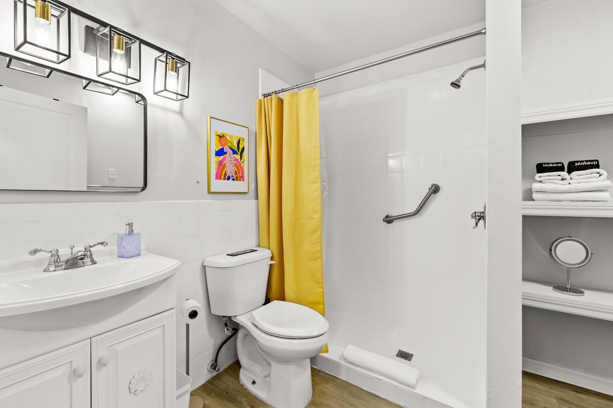Een badkamer met een wit wastafel, toilet en douchegedeelte met een geel douchegordijn.