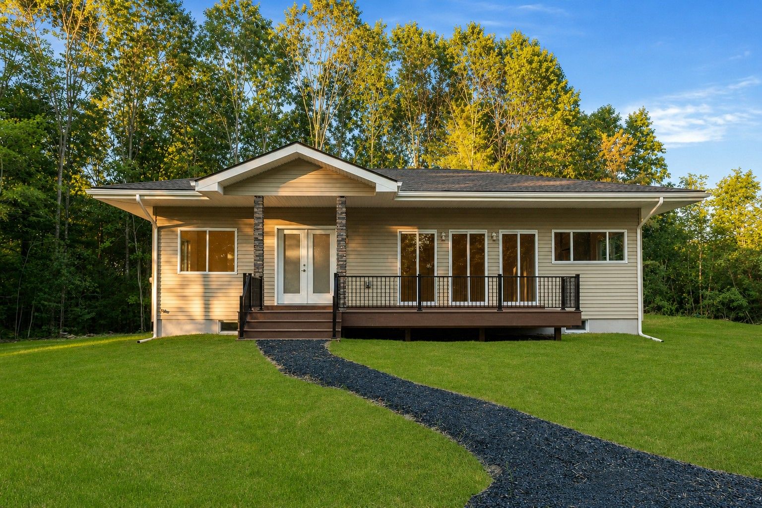 A single-story house with a front porch, a driveway, and a well-maintained lawn.