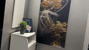 A reception desk with a potted plant, a framed map, and a wall-mounted mirror. - G&A Luxe Apartment Central (Târgu Jiu)