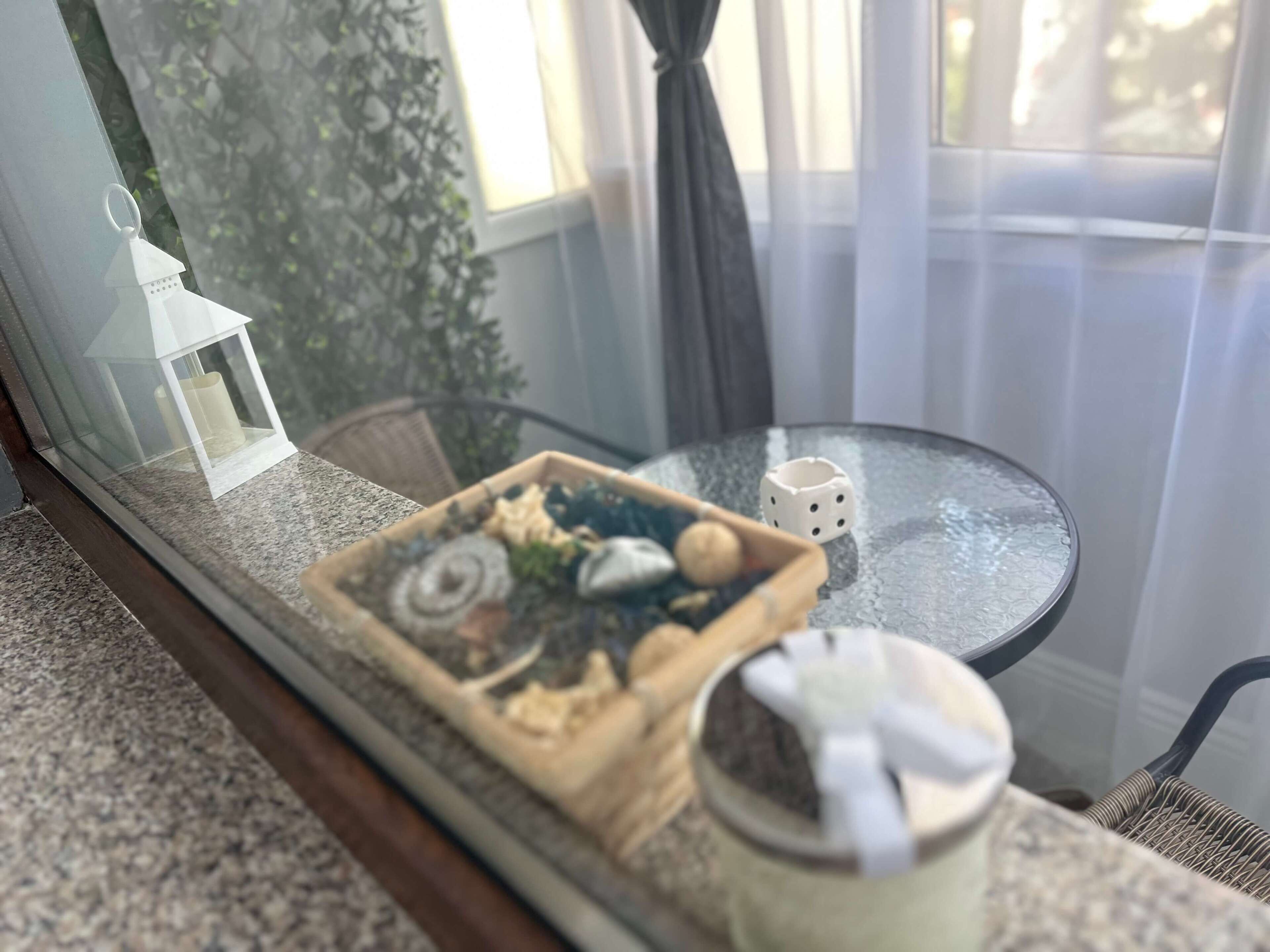 Una pequeña mesa redonda con una bandeja de aperitivos, una taza blanca y un objeto blanco pequeño encima.