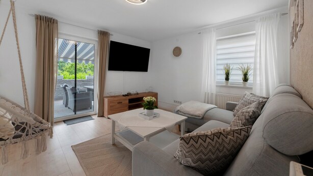 A modern living room with a sofa, coffee table, and a hanging chair. - Stay in the Heart of Nature (Sankt Wendel)