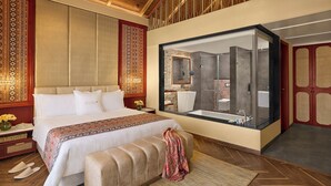 Un dormitorio amplio con una cama grande, un baño con cabina de ducha de cristal y techo de madera.