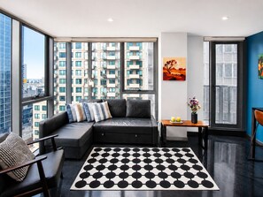 A modern living room with a sectional sofa, a coffee table, and a patterned rug.