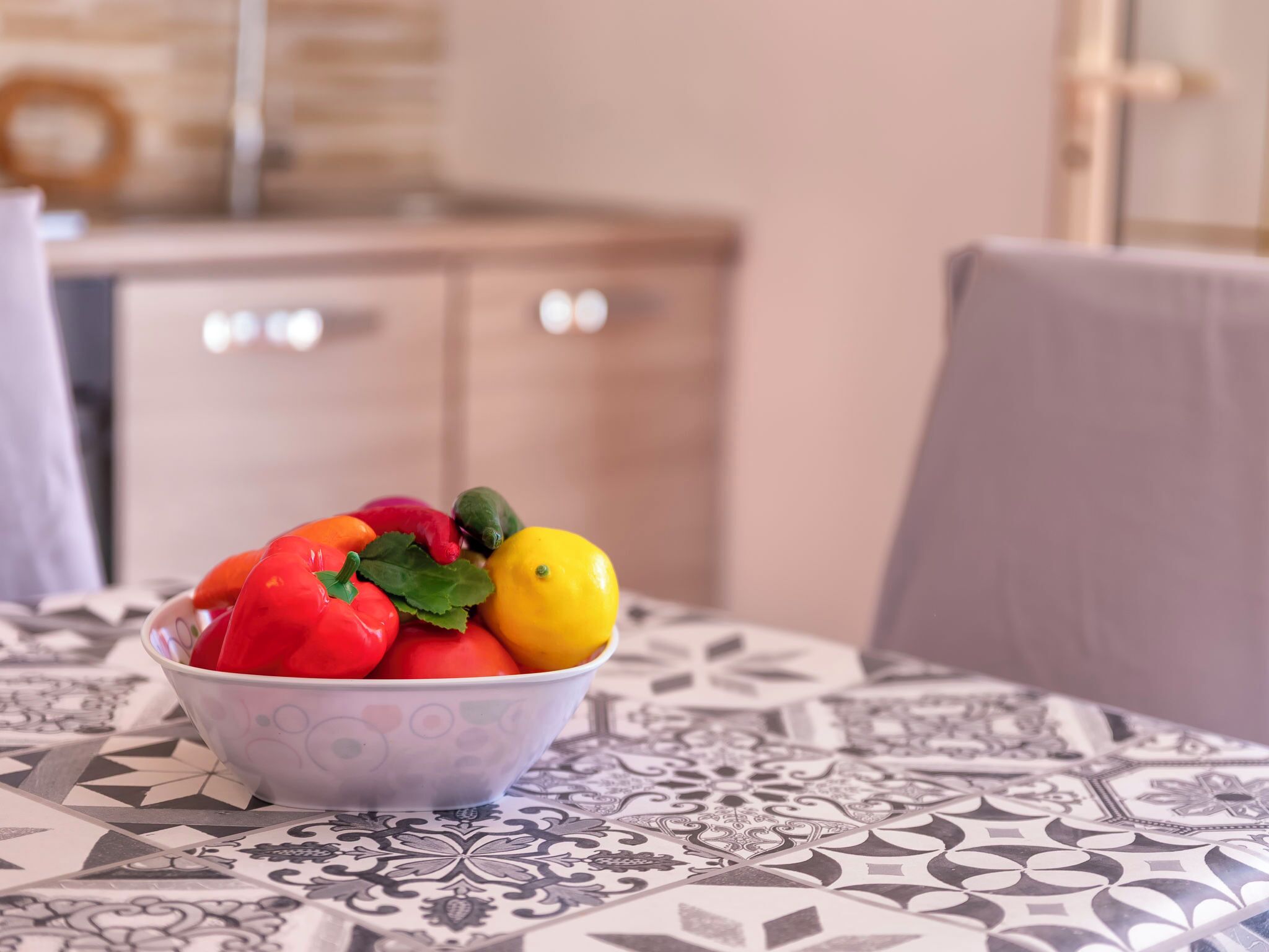 Eine Schüssel mit bunten Früchten auf einer gemusterten Tischdecke.