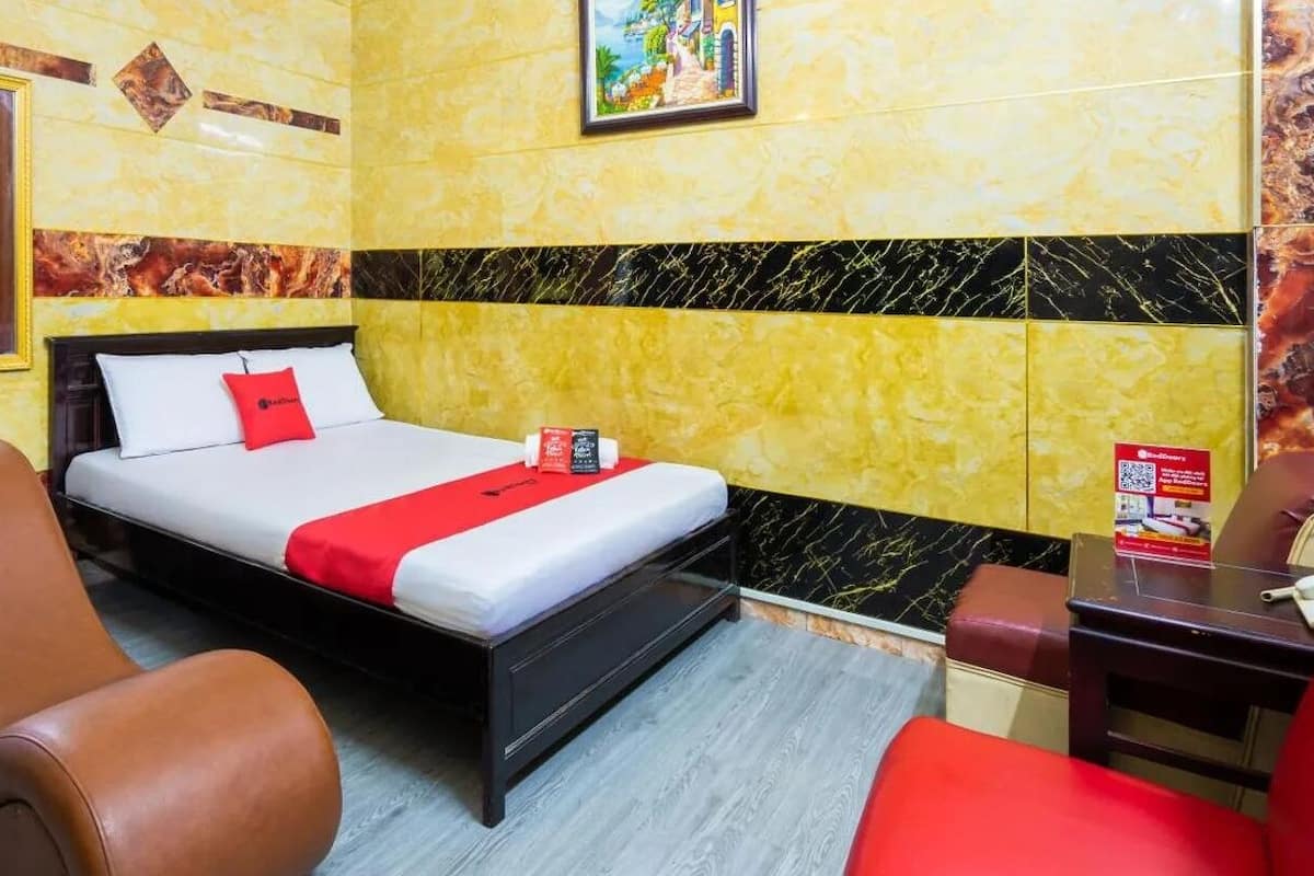 Une chambre d’hôtel avec un lit, une chaise, un bureau et un miroir.