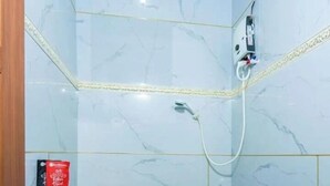 Un bany amb un lavabo blanc, un vàter i una dutxa.